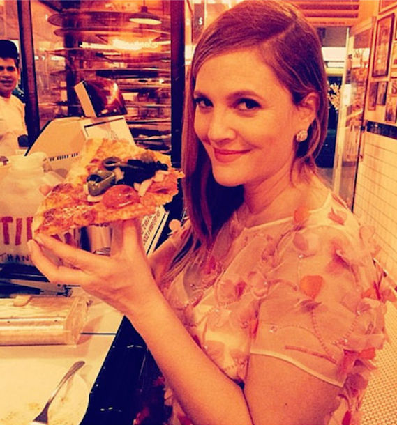 Drew Barrymore eating a slice of pizza