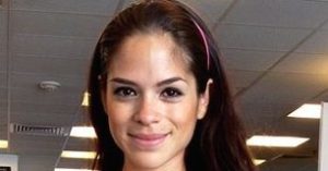 Michelle Lewin working out in the gym with dumbbells.