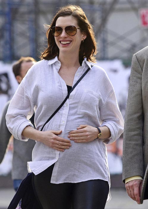 Anne Hathaway rubs growing baby bump while out with parents in NYC on December 16, 2015