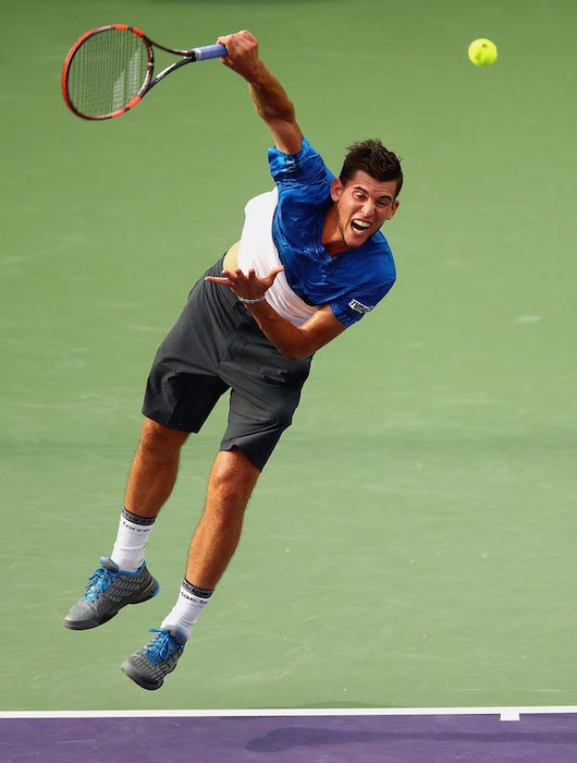 Dominic Thiem serves against Novak Djokovic in a Miami Open at Crandon Park Center on March 29, 2016