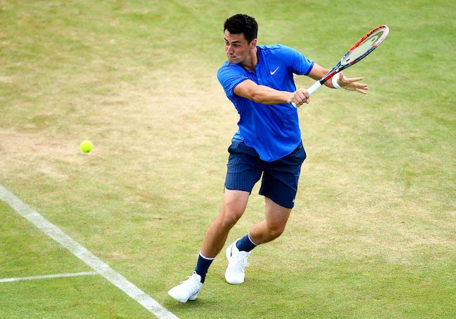 Bernard Tomic trying to return the ball with a backhand shot in a match of the Aegon Tournament against Gilles Muller on June 17, 2016