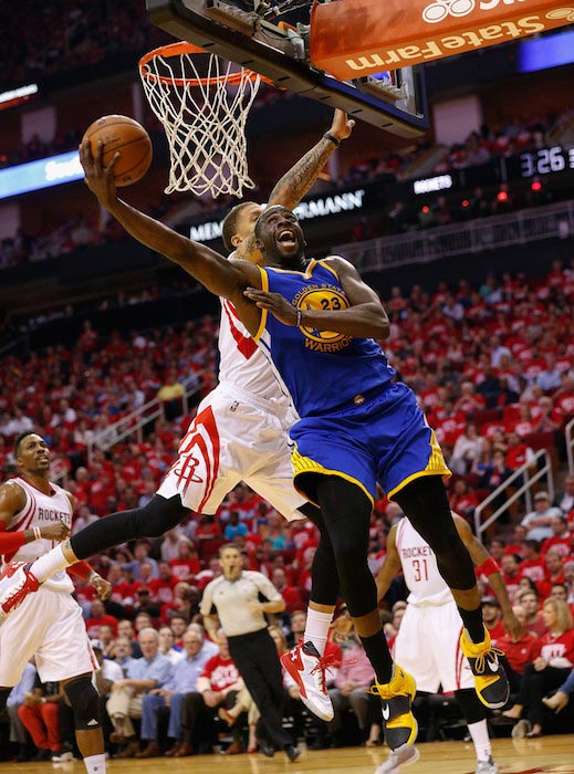 Draymond Green tries to score over Michael Beasley of Houston Rockets during a match on April 21, 2016