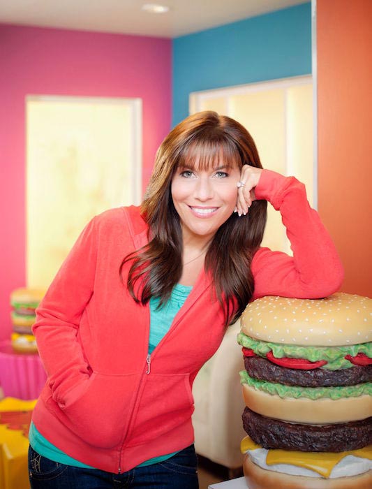 Lisa Lillien leaning on a burger prop