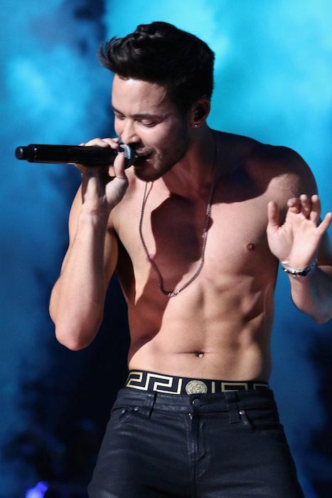 Prince Royce showing off his body while performing on stage