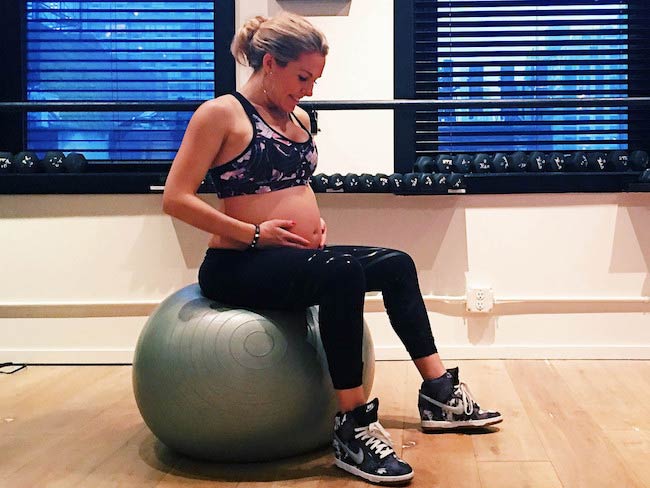Pregnant Anna Kaiser exercising on the ball