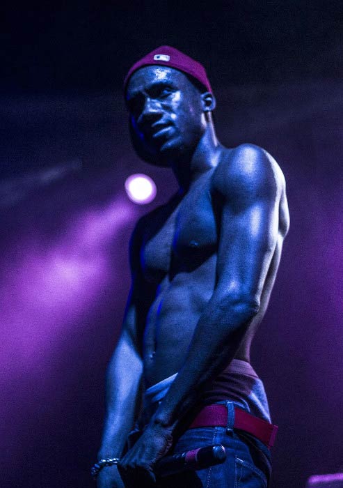 Hopsin shirtless performing on stage at his concert in 2015