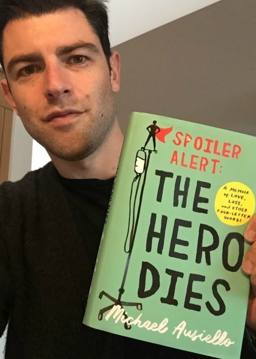 Max Greenfield holding the book The Hero Dies by Michael Ausiello in December 2017