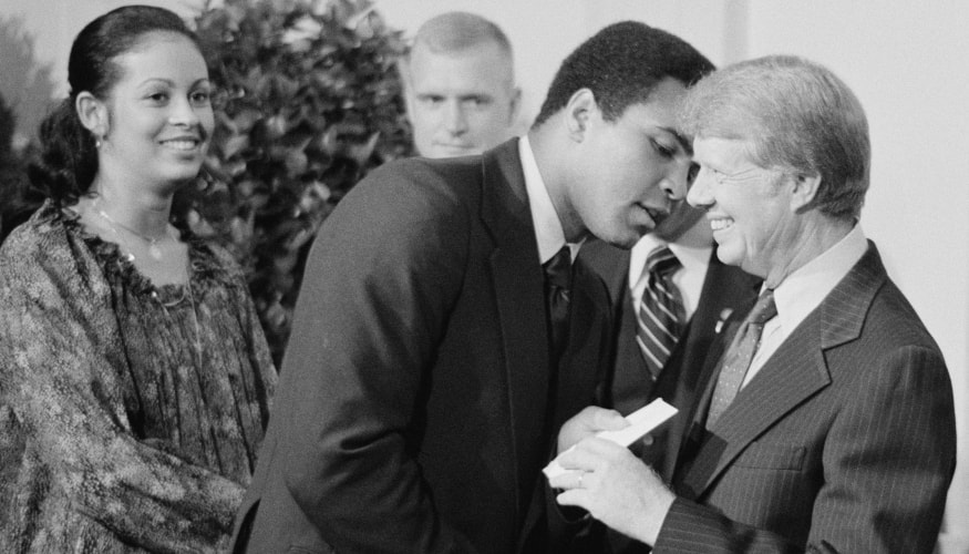 Muhammad Ali, accompanied by his wife Veronica Porsche Ali , exchanging greetings with President Jimmy Carter while attending a White House dinner celebrating the signing of the Panama Canal Treaty Washington, D.C.