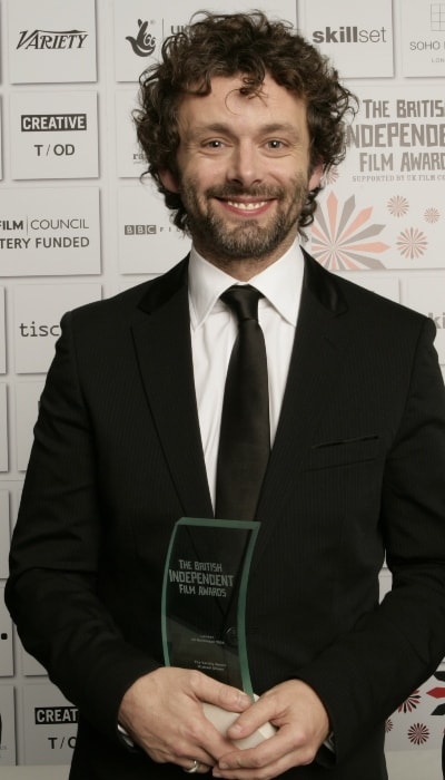 Michael Sheen posing with his BIFA Award