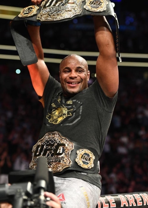 Daniel Cormier showing his belts in July 2018