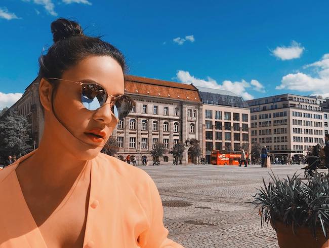KC Concepción wearing Ray Ban sunglasses in the bright sun at Gendarmenmarkt Berlin in May 2018