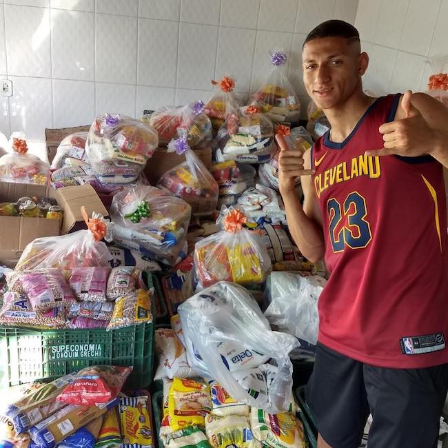 Richarlison posing with food collected from the charity match in May 2018