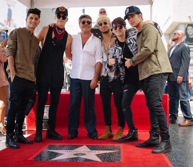 Christopher Vélez and other CNCO members posing with Simon Cowell
