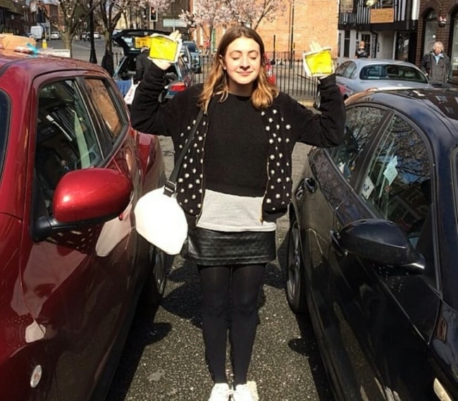 Georgia Groome posing beside the cars