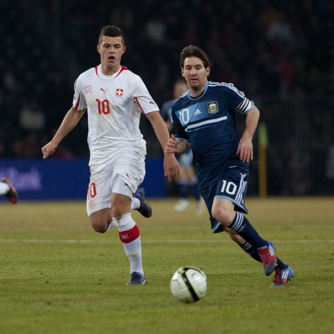 Granit Xhaka (Left) chasing the ball alongside Lionel Messi in a match in February 2012