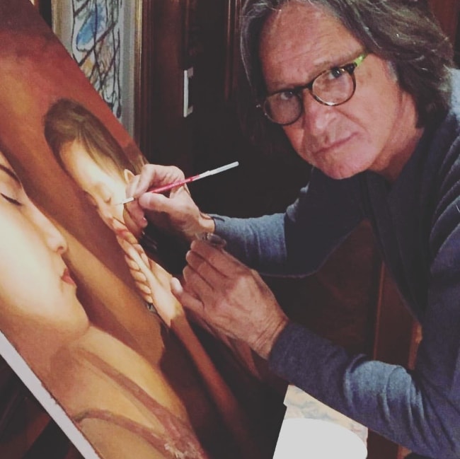 Mohamed Hadid posing for the camera while painting in August 2018
