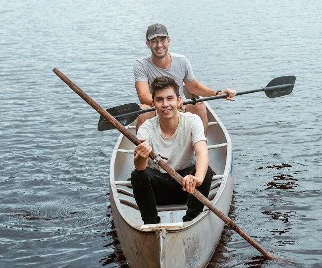 Sam Tsui canoeing with Joel Manduke behind him in August 2018