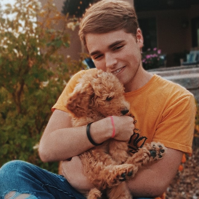 Trey Ovard playing with a puppy named Graham in August 2018