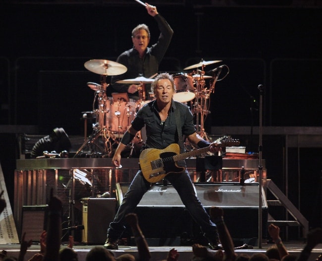 Bruce Springsteen performing at a concert with Max Weinberg in the back in August 2008