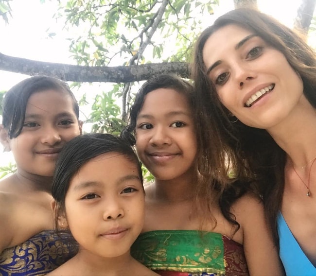 Cansu Dere in a selfie with some kids in Bali, Indonesia in June 2017