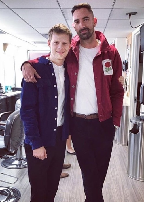 Lucas Hedges in a blue shirt and ginger hair while posing for the camera