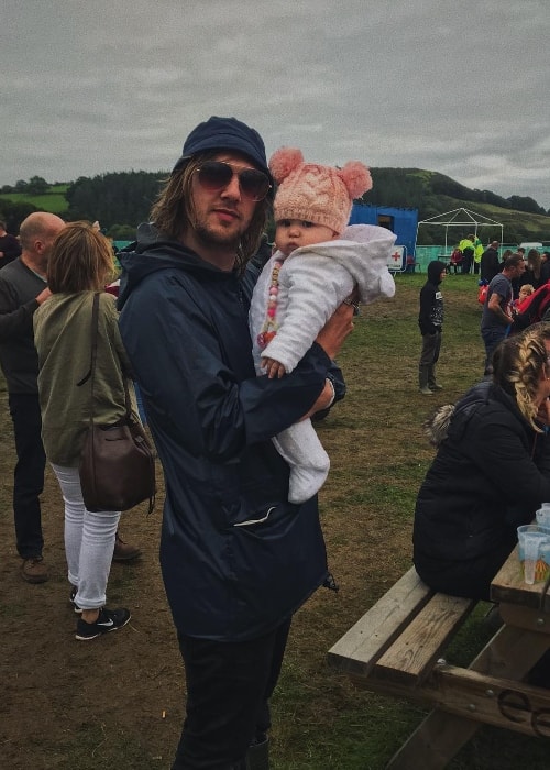 Gethin Davies posing with a baby at The Big Tribute Festival in August 2018