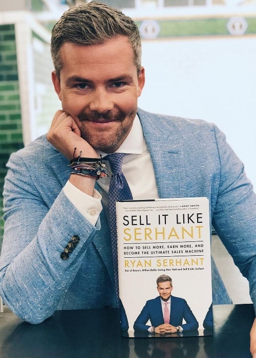 Ryan Serhant posing with his book in September 2018