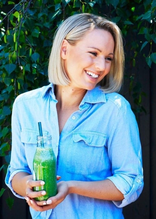 Steph Wearne smiling while posing with a juice container