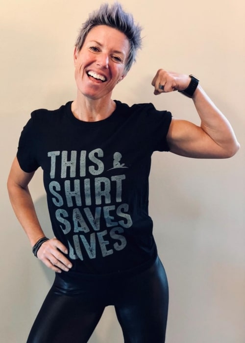 Erin Oprea posing for the camera wearing a 'This Shirt Saves Lives' shirt