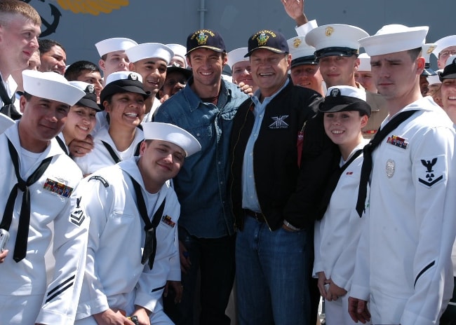 Kelsey Grammer (Center Right) and Hugh Jackman (Center Left) posing with crew members on the flight deck aboard the amphibious assault ship USS Kearsarge (LHD 3) in May 2006