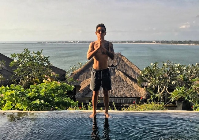 Axel Matthew Thomas posing shirtless at Four Seasons Resort Bali at Jimbaran Bay in July 2017