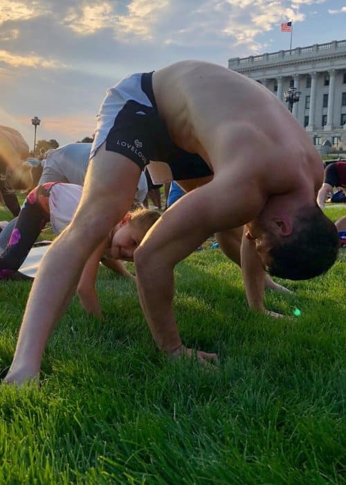 Dan Reynolds doing yoga in a park in July 2018