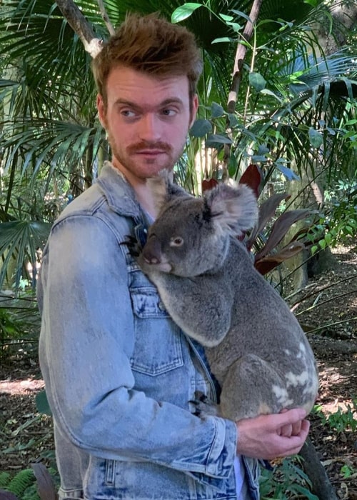 Finneas O'Connell as seen while holding a koala bear in a picture taken at the Lone Pine Koala Sanctuary located in Queensland, Australia in May 2019