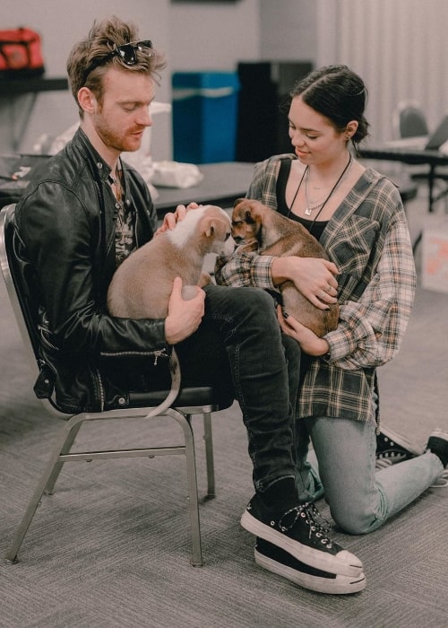 Finneas O'Connell as seen while petting two puppies along with Claudia Sulewski in June 2019