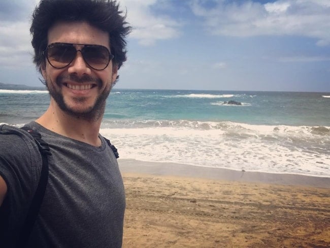 Álvaro Morte as seen while taking a selfie by a beach in April 2018