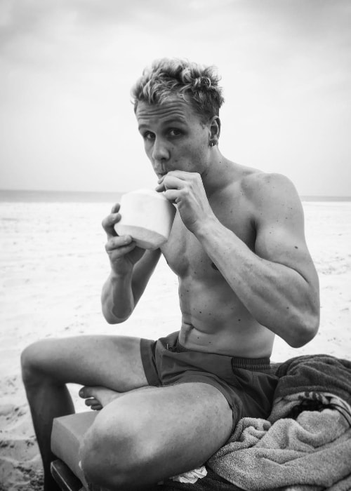 Josh Dylan as seen in an stunning shirtless black-and-white picture while drinking coconut water in March 2019