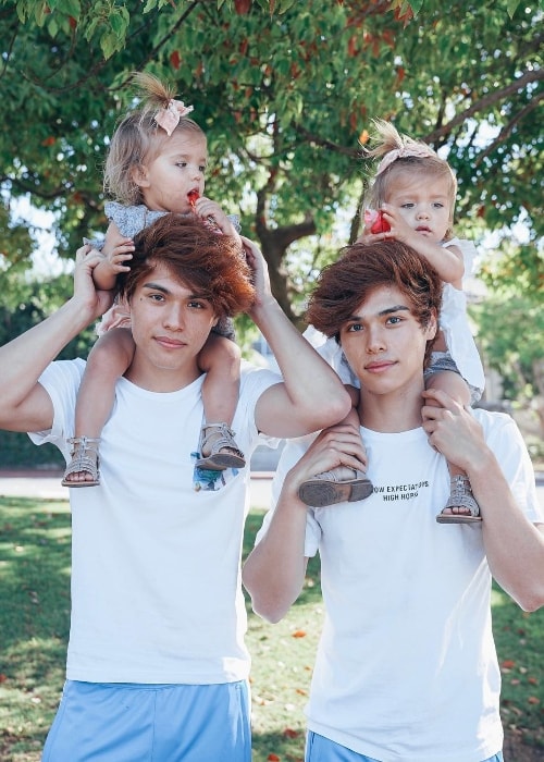 Taytum Fisher and Oakley Fisher as seen while posing for the camera while resting on the shoulders of twin brothers, Alan Stokes and Alex Stokes, in August 2018