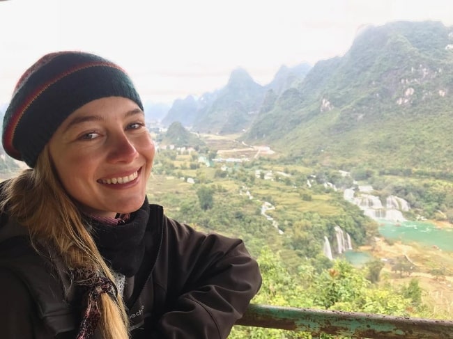 Charlotte Vega as seen while smiling for a picture at Thác Bản Giốc - Ban Gioc Waterfall in December 2018