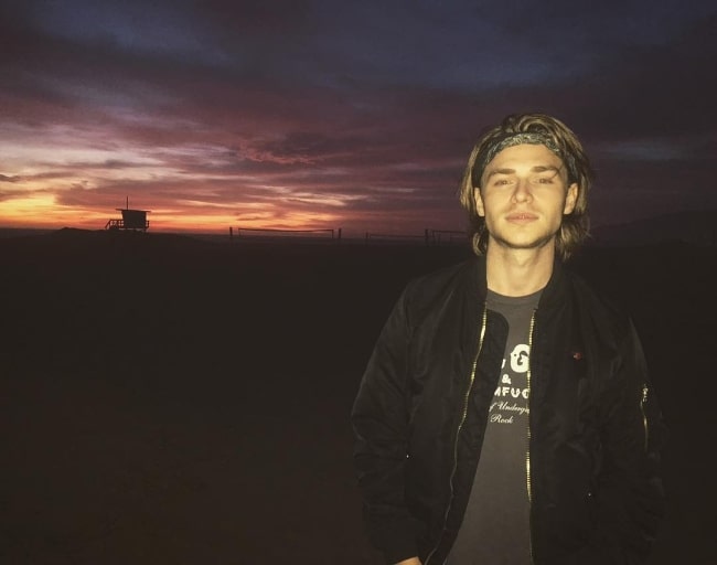 Keenan Tracey as seen while smiling for a picture at Malibu Beach in Los Angeles County, California in January 2018