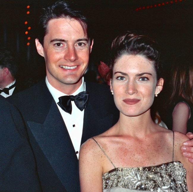 Lara Flynn Boyle as seen while smiling for the camera along with Kyle MacLachlan at the 42nd Emmy Awards - Governor's Ball in September 1990