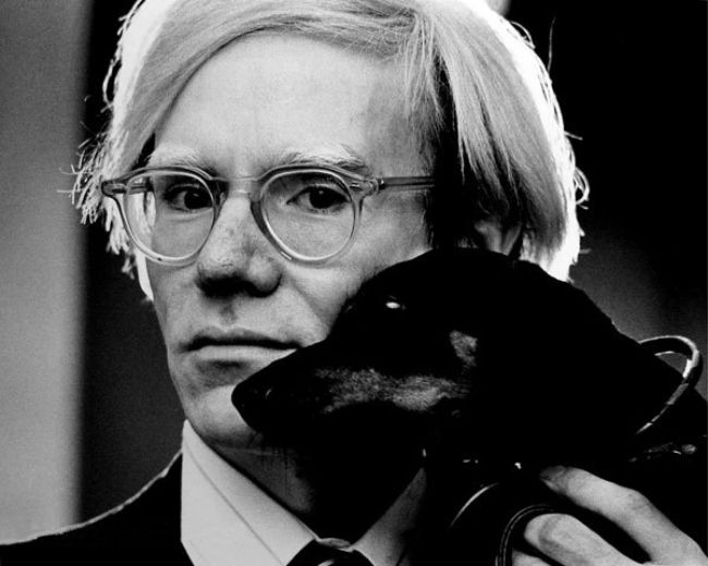 Andy Warhol posing with his pet dog Archie in 1973
