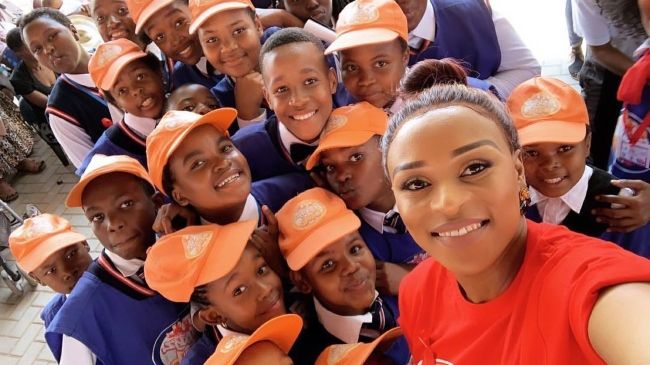 DJ Zinhle taking a selfie with school kids in February 2019