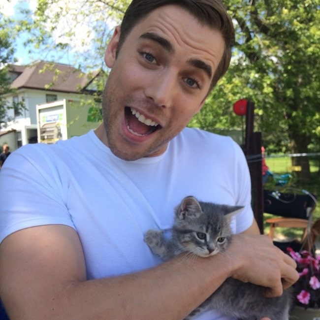 Dustin Milligan as seen while posing for a picture with a cat in June 2015