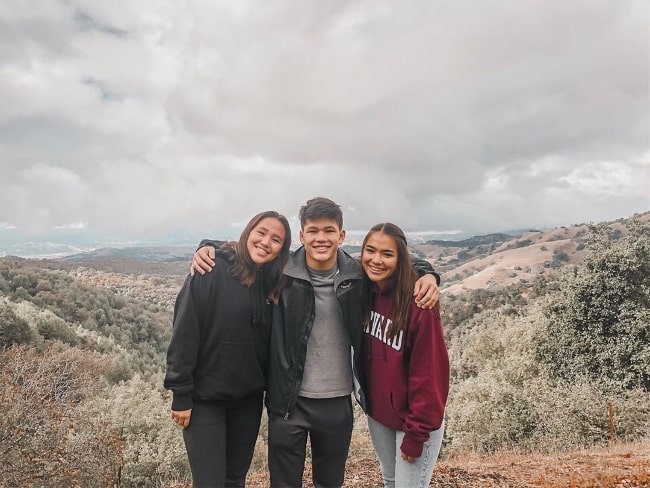 Niko Katsuyoshi posing for a picture alongside Mia Katsuyoshi (Right) and Kylie Katsuyoshi (Left) in November 2019