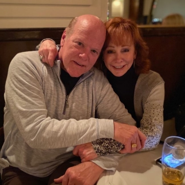 Rex Linn and Reba McEntire smiling for a picture while enjoying a dinner in January 2020