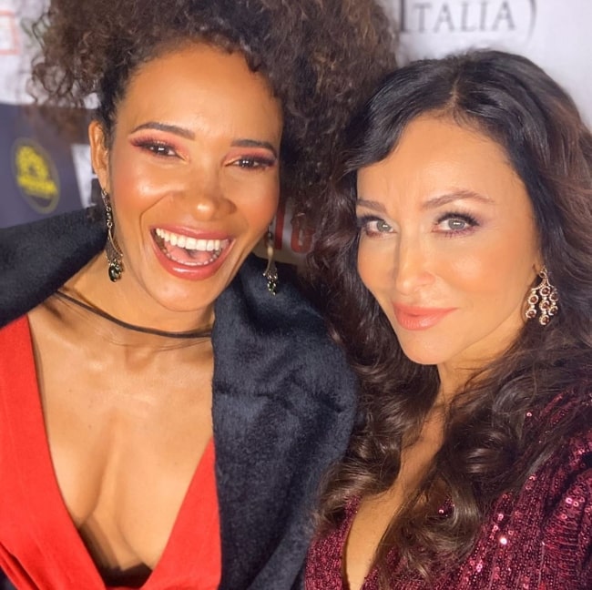 Sofia Milos (Right) smiling in a selfie alongside Denny Mendez at TCL Chinese Theatre in Los Angeles, California in February 2020