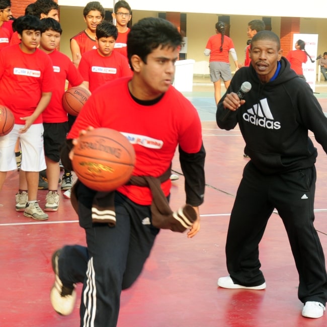 Former NBA player Muggsy Bogues, right, coaches students from the Mahindra NBA challenge youth league