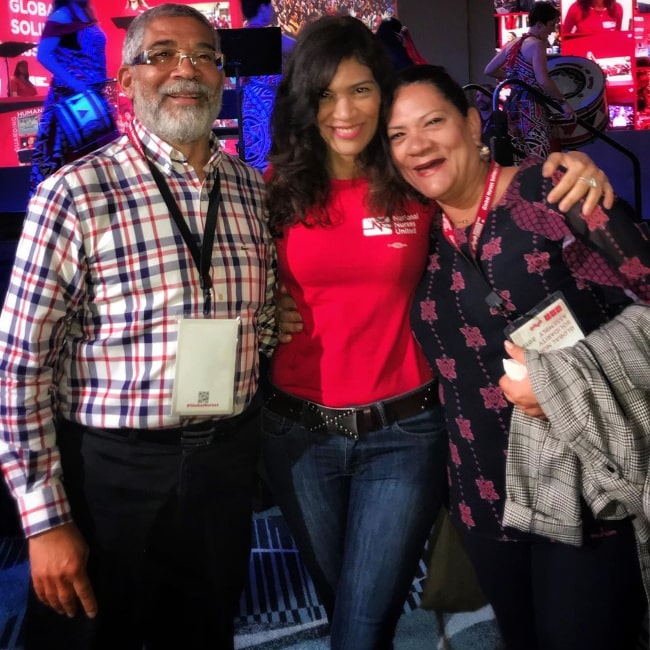 Laura Gómez posing for a picture alongside her parents