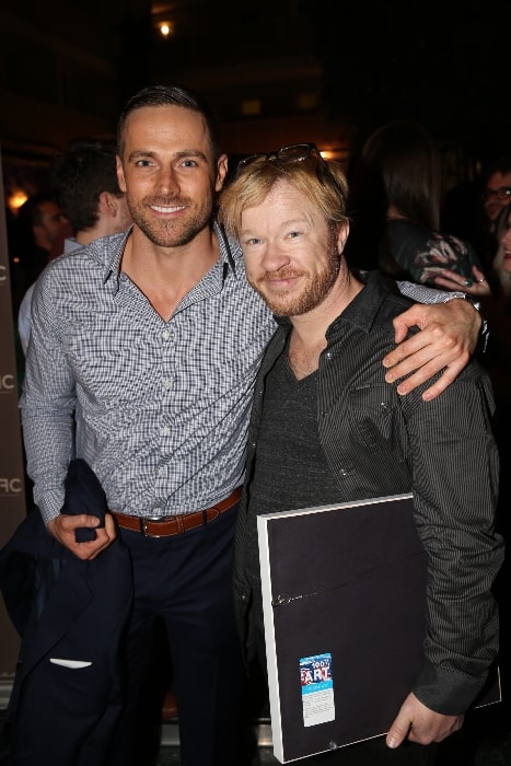 Dylan Bruce (Left) as seen while posing for the camera alongside John Fawcett at the CFC event in Los Angeles, California in May 2015