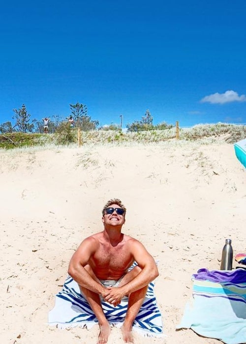 Lincoln Lewis soaking up the sun on a beach in January 2019